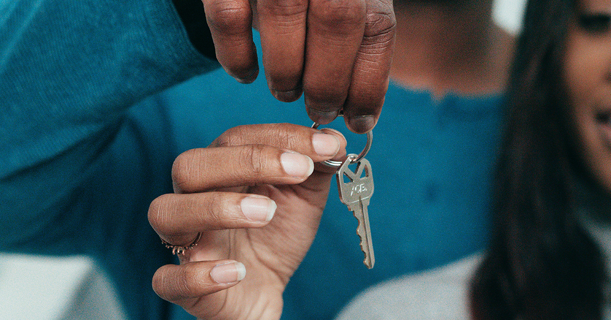 Two people holding a key